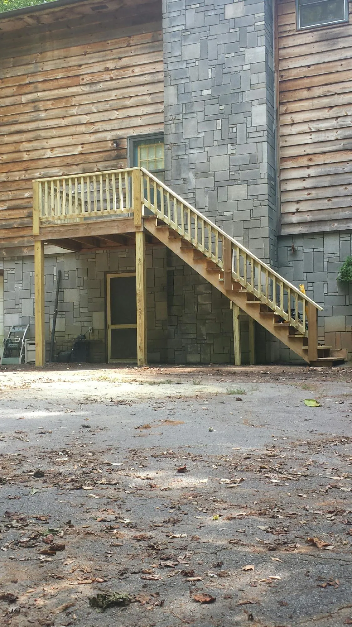 New pressure treated deck and stair landing on a log home in Clearwater
