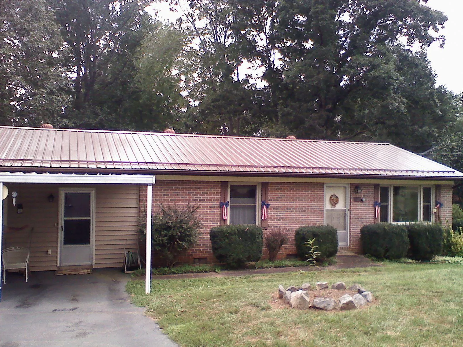 Bronze metal roof and carport on a brick ranch home — Roof Repair work by our crew in Clearwater